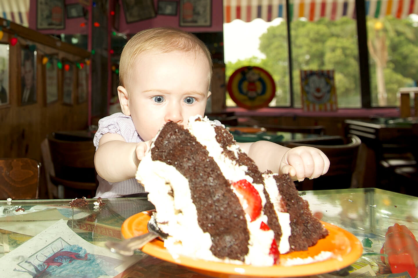 baby_with_cake A baby Inside The Bubble Room restaurant reaching for one of the iconic cakes